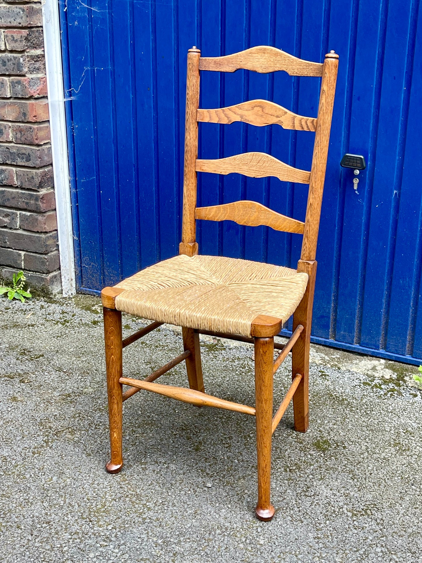 A Set Of Five Arts And Crafts Oak Rush-Seated Ladder Back Dining Chairs