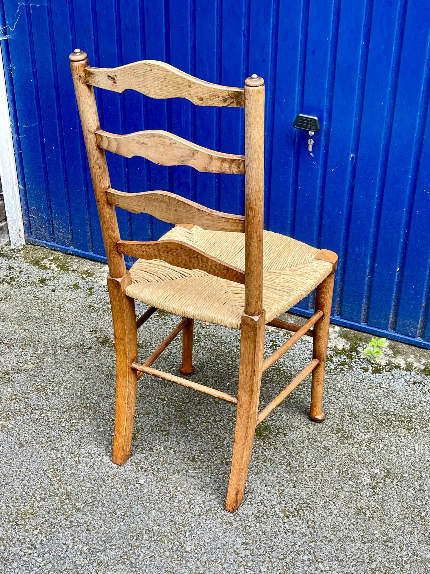A Set Of Five Arts And Crafts Oak Rush-Seated Ladder Back Dining Chairs
