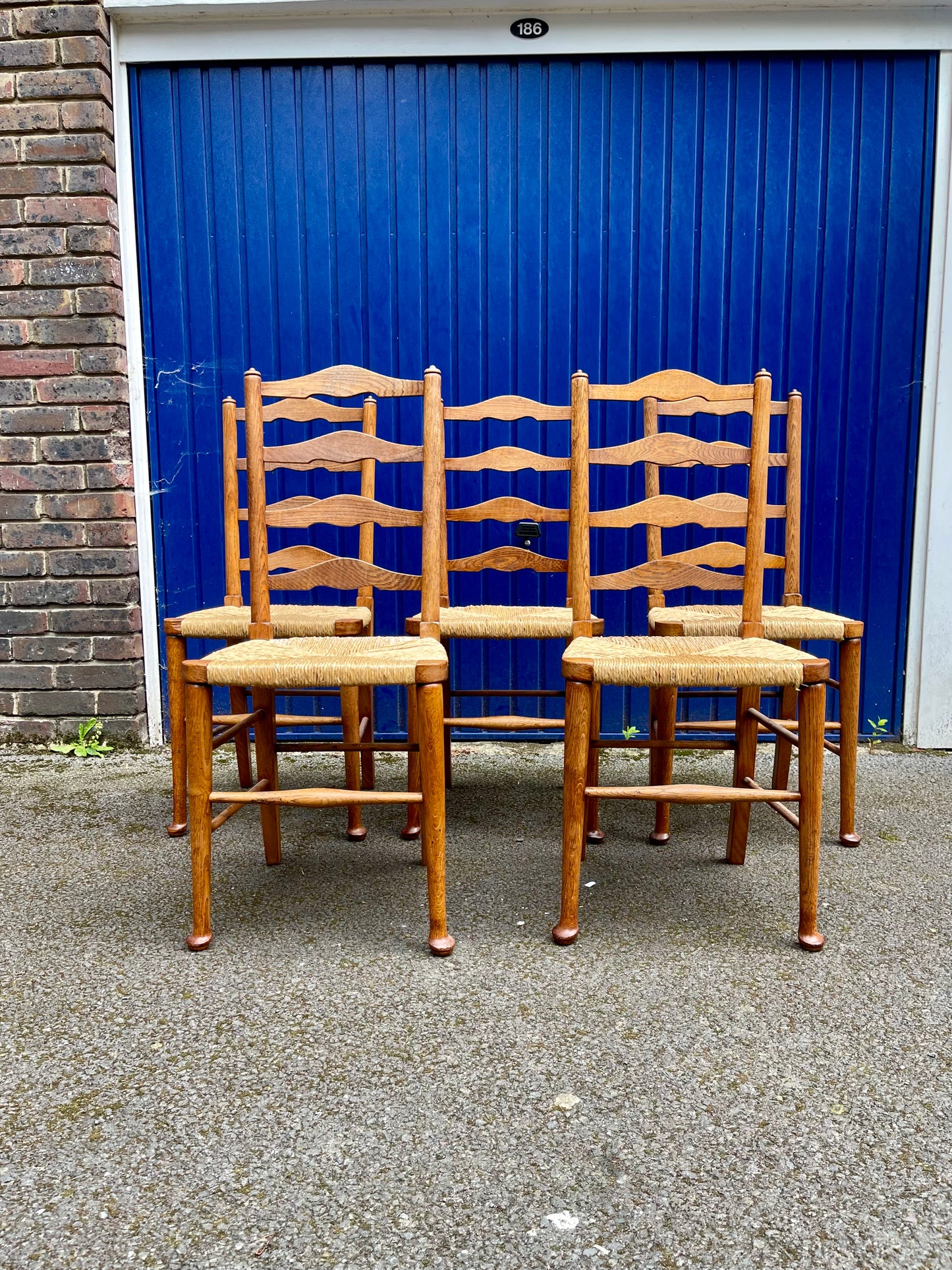 A Set Of Five Arts And Crafts Oak Rush-Seated Ladder Back Dining Chairs